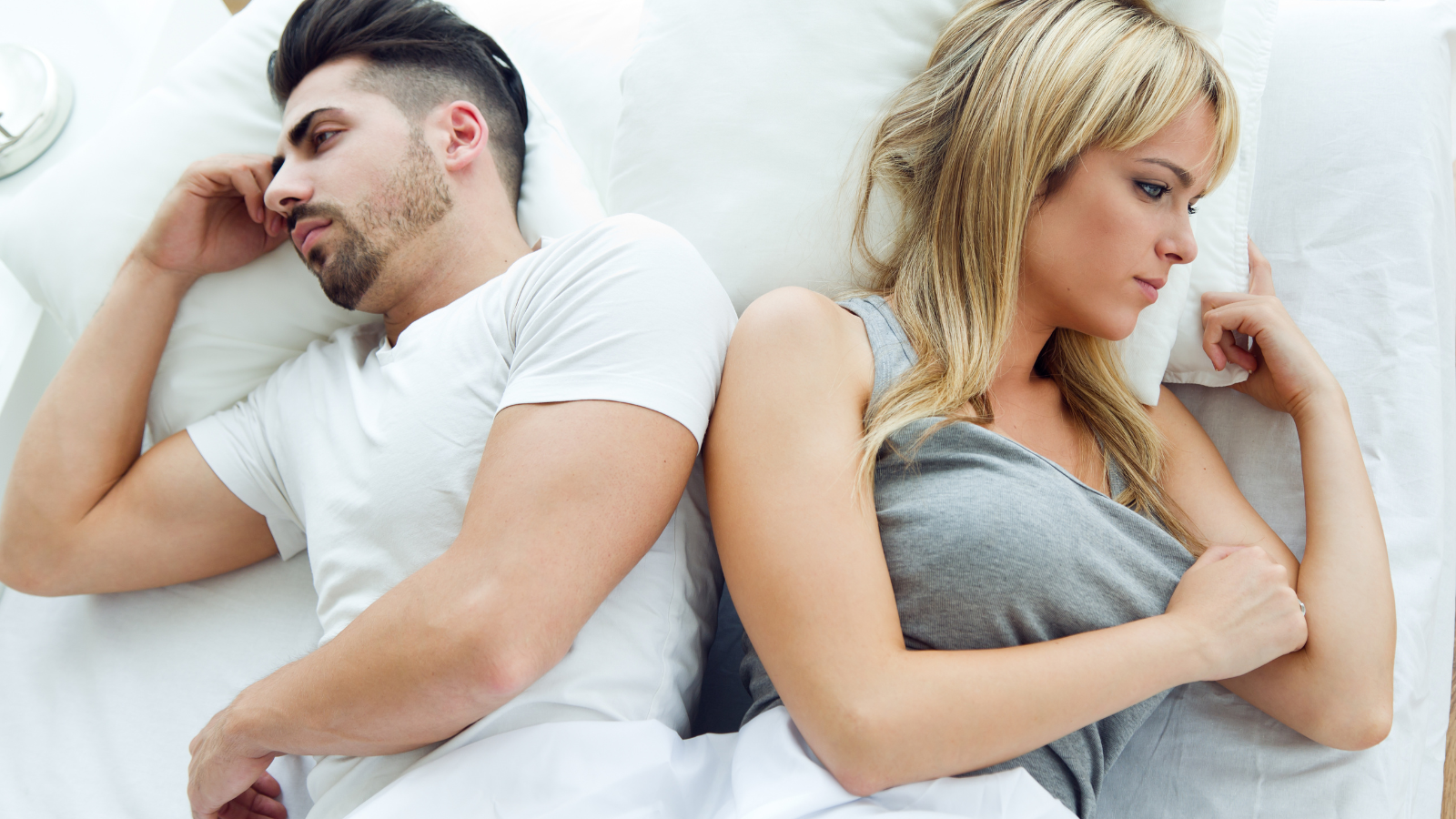 Ein Pärchen im Bett mit Rücken zu einander, Symbolbild für Sexualität bei vermeidendem Bindungsstill